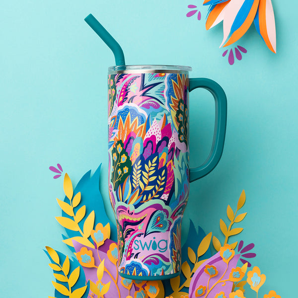 Swig Life Insualted Bazaar 30oz Mega Mug on a blue background with colorful plants