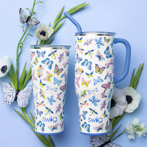 Swig Life Butterfly Bliss Insulated 32oz Tumbler and 40oz Mega Mug surrounded by flowers and butterflies on a blue background