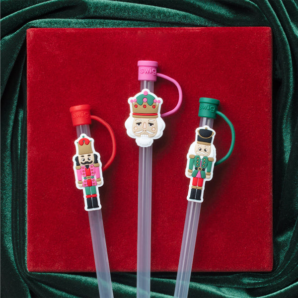 Swig Life Classic Nutcracker Straw Topper Set on a velvet holiday green and red background