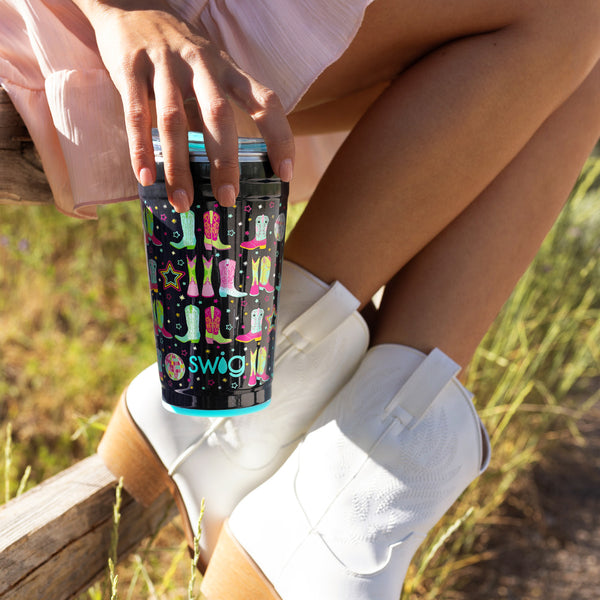 Swig Life 24oz Disco Cowgirl Insulated Party Cup being held by a women with cowboy boots