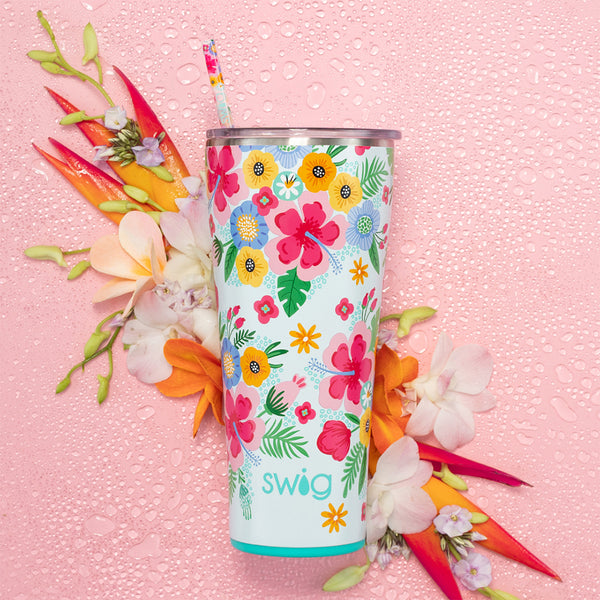 Swig Life 32oz Island Bloom Insulated Tumbler on a pink background with tropical flowers