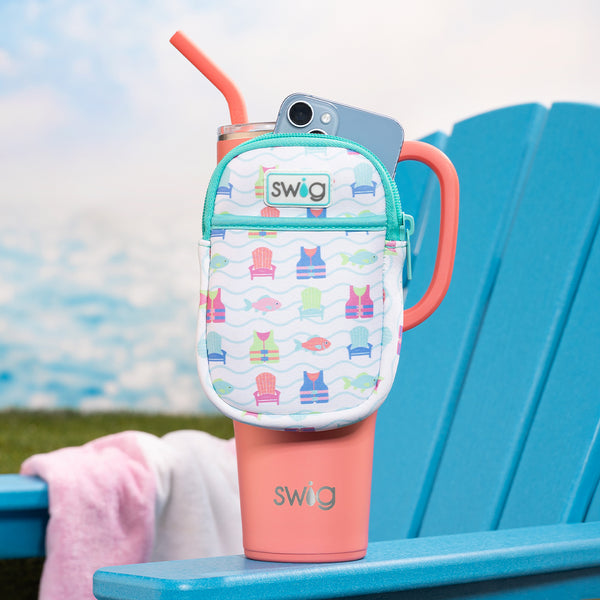 Swig Life Lake Girl Neoprene Mega Mug Pouch on a Coral 40oz Mega Mug sitting on an Adirondack chair