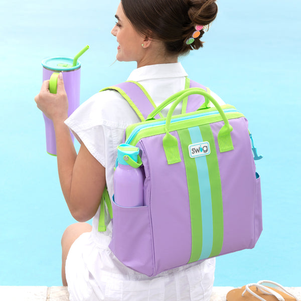 Swig Life Ultra Violet Insulated Packi Backpack worn by a women holding a 40oz Mega Mug sitting poolside