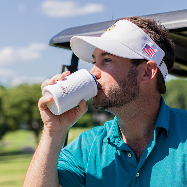 Man on a golf course holding a Swig Life 12oz Golf Partee Insulated Can + Bottle Cooler