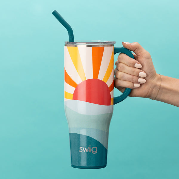 Swig Life 40oz Sun Dance Insulated Mega Mug being held over a blue background